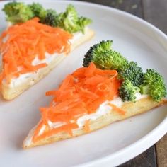 three pieces of pizza with carrots and broccoli on it sitting on a plate