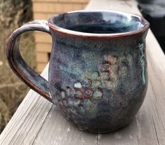 a blue mug sitting on top of a wooden table