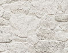 an old white stucco wall with cracks in it