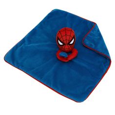 a spiderman plush toy on top of a blue blanket