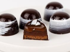 four pieces of chocolate dessert on a white plate