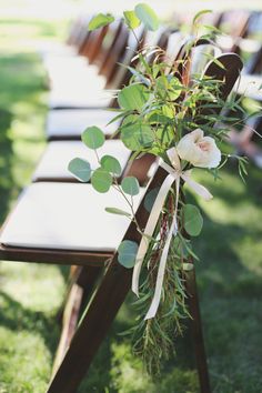 a row of wooden benches sitting on top of a lush green field