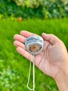 Montana Agate bolo chain necklace. I’ve been holding onto this stone since April of 2023 because I knew it was destined for a special project like this one. The stone was ethically sourced and cut by a fellow female-owned small business. The Montana agate has a sunset scene in it, with the orange being the setting sun and the lines looking like mountains to me. I designed this so it looks like the setting sun below the mountain, which I carved out of the silver. This piece was made with an extre Handmade Sterling Silver Bolo Tie As Gift, Agate Jewelry With Adjustable Chain, Adjustable Oval Agate Jewelry, Artisan Lariat Necklace Gift, Artisan Necklace With Large Adjustable Stone, Adjustable Agate Necklace With Large Stone, Handmade Agate Lariat Jewelry, Adjustable Agate Jewelry With Chain, Artisan Lariat Necklace With Natural Stones For Gift