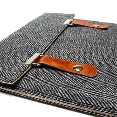 an ipad case with a leather handle on the front and back cover is made out of grey herringies