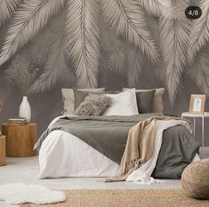 a bed room with a neatly made bed and a wallpapered mural behind it