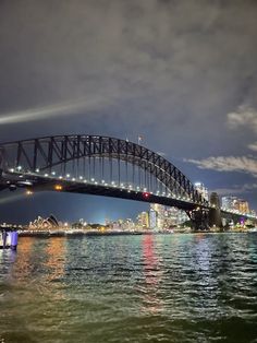 the sydney harbour bridge is lit up at night