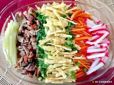 a glass bowl filled with different types of vegetables and meats on top of each other