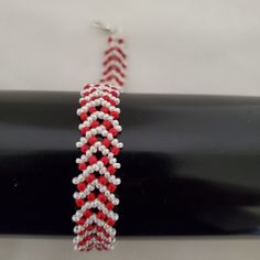 a red and white beaded bracelet is on display