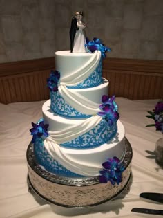 a blue and white wedding cake on a table