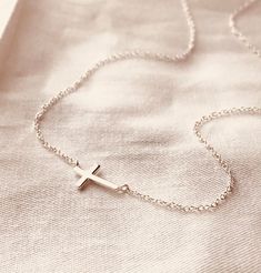 Adorn yourself with this delicate 925 Sterling Silver Cross Necklace featuring a mini cross pendant. Crafted from authentic sterling silver, its high polish finish offers a timeless and lasting shine. Its simple yet elegant design makes it a perfect accessory for everyday wear or special occasions. The model is wearing 18 inches in 925 sterling silver.Item Details: • This listing is for (1) mini cross necklace.• All metal components are 925 sterling silver.• Cross size about 7mmx10mm.Ultra daint Silver Cross Necklace With Delicate Chain, Silver Sterling Cross Necklace With Delicate Chain, Simple Sterling Silver Cross Pendant Necklace, Sterling Silver Cross Necklace With Delicate Chain, Minimalist Sterling Silver Cross Necklace, Minimalist White Gold Sterling Silver Cross Necklace, Dainty White Gold Cross Necklace, Sideways Cross Necklace, Cross Necklace Sideways