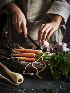 a person chopping carrots on top of a cutting board