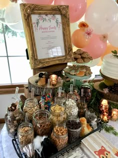 a table topped with lots of desserts and balloons