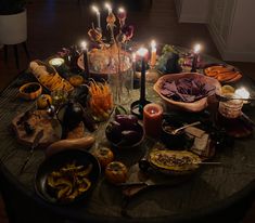 a table topped with lots of different types of food and candles on top of it