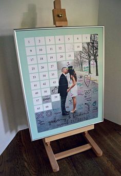 a calendar on a easel with a couple holding each other in front of it