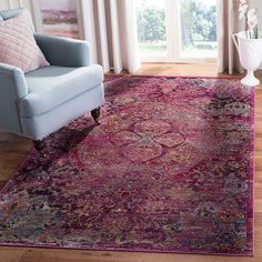 a living room with a blue chair and pink rug