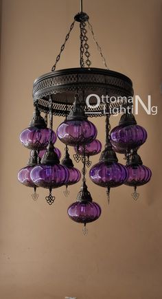 a chandelier hanging from the ceiling with purple glass shades and ornate metal fittings