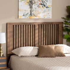 a bedroom with a bed, nightstand and painting on the wall above it's headboard