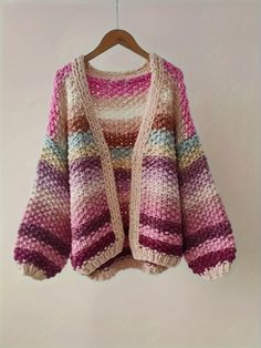 This sweater is a cozy, oversized knit cardigan with a gradient color pattern. It features a variety of pastel and muted hues, blending seamlessly from one color to the next. The color palette includes shades of pink, purple, beige, and hints of blue and green, creating a soft and dreamy appearance. The knit fabric is chunky and textured, providing warmth and a comfortable fit. The sweater has a loose, relaxed silhouette with dropped shoulders and wide sleeves, giving it an effortlessly chic and Casual Pink Knitted Outerwear, One Size Multicolor Soft Knit Cardigan, Pink Open Knit Winter Sweater, Pink Open Knit Sweater For Winter, Winter Pink Open Knit Sweater, Oversized Pink Sweater Coat For Fall, Trendy Oversized Pink Sweater Coat, Oversized Pink Sweater Coat Long Sleeve, Multicolor Open Knit Cardigan