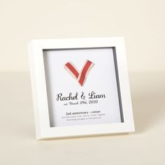 a white frame with a red ribbon in the shape of a v on it's side