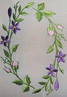 an embroidered wreath with purple flowers and green leaves