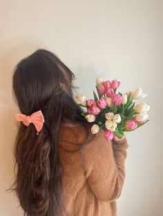 Girl is holding a bunch of tulips. They are pink and white and she is holding them over her shoulder facing away from the camera. She I wearing a brown cardigan and a pink bow in her hair. Flowers Poses Ideas, Aesthetic Pic For Dp, Flower Poses Photo Ideas, Girl With Flowers Aesthetic, Aesthetic Pfp Girl, Mid Sized Fashion, Pfp Ideas Aesthetic, Pose With Flowers