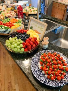 a counter topped with lots of different types of fruits and veggies on plates