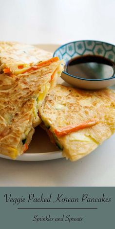 a plate topped with quesadillas next to a bowl of dipping sauce