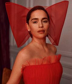 a woman in a red dress with a veil on her head and an earring