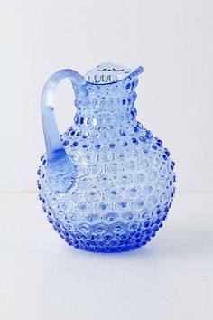 a blue glass pitcher sitting on top of a table