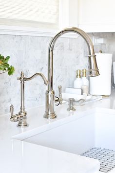 a kitchen sink with two faucets and soap dispensers on the counter