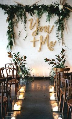 an aisle with candles and greenery is decorated with wooden letters that spell out you're