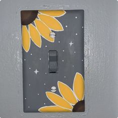 a light switch cover with sunflowers painted on it