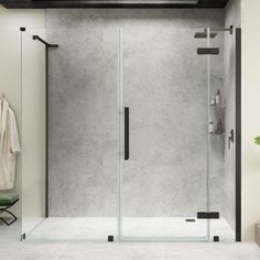 a walk in shower sitting next to a white tiled wall and floor with a towel hanging on the door