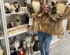 a woman standing in front of shelves filled with stuffed animals and gnomes on display