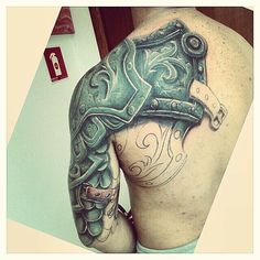 the back of a man's body with tattoos on it and a hammer in his hand