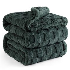 three towels stacked on top of each other in dark green color, one folded up and the other folded down