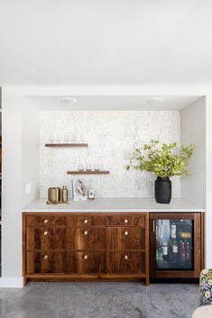 a room that has some shelves on the wall and a vase with flowers in it