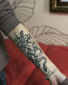 a woman's arm with a flower tattoo on it