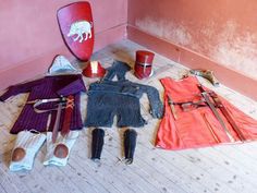 an assortment of clothing and accessories laid out on the floor next to a red wall