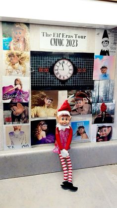 there is a elf standing in front of a wall with pictures on it