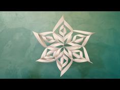 a paper snowflake on a green background