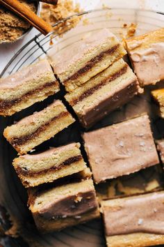 slices of cake sitting on top of a glass plate next to cinnamon sticks and powdered sugar