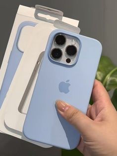 a person holding up an iphone case in front of two boxes with the cover open