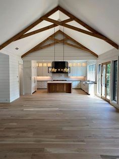 an open floor plan with wood floors and white walls, large windows on both sides