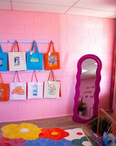 there are many bags hanging on the wall in this child's playroom area