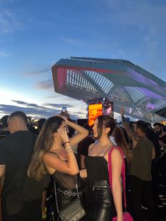 two women standing next to each other in front of a crowd