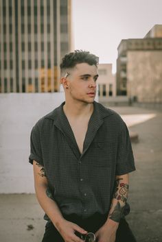 a man with tattoos sitting on the ground