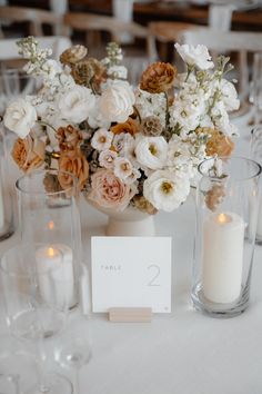 the table is set with candles, flowers and place cards for guests to sit at