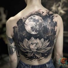 the back of a woman's shoulder with a full moon and lotus tattoo on it