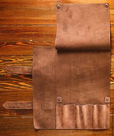 a brown leather case sitting on top of a wooden table